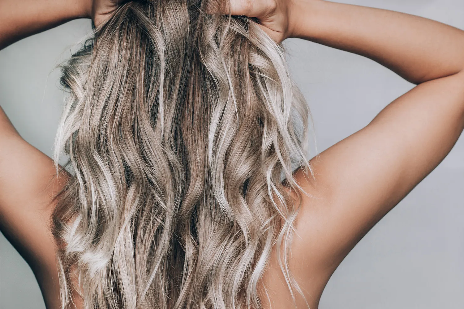 Lang blond haar met losse krullen, van achteren gezien