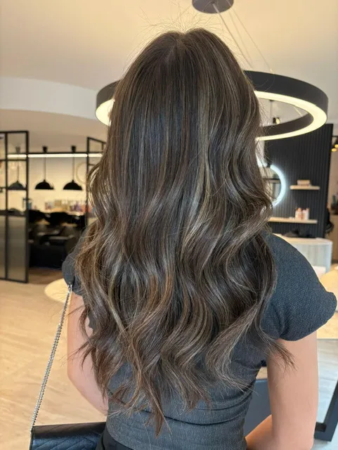 Lang, vol bruin haar met golven na een behandeling in het salon