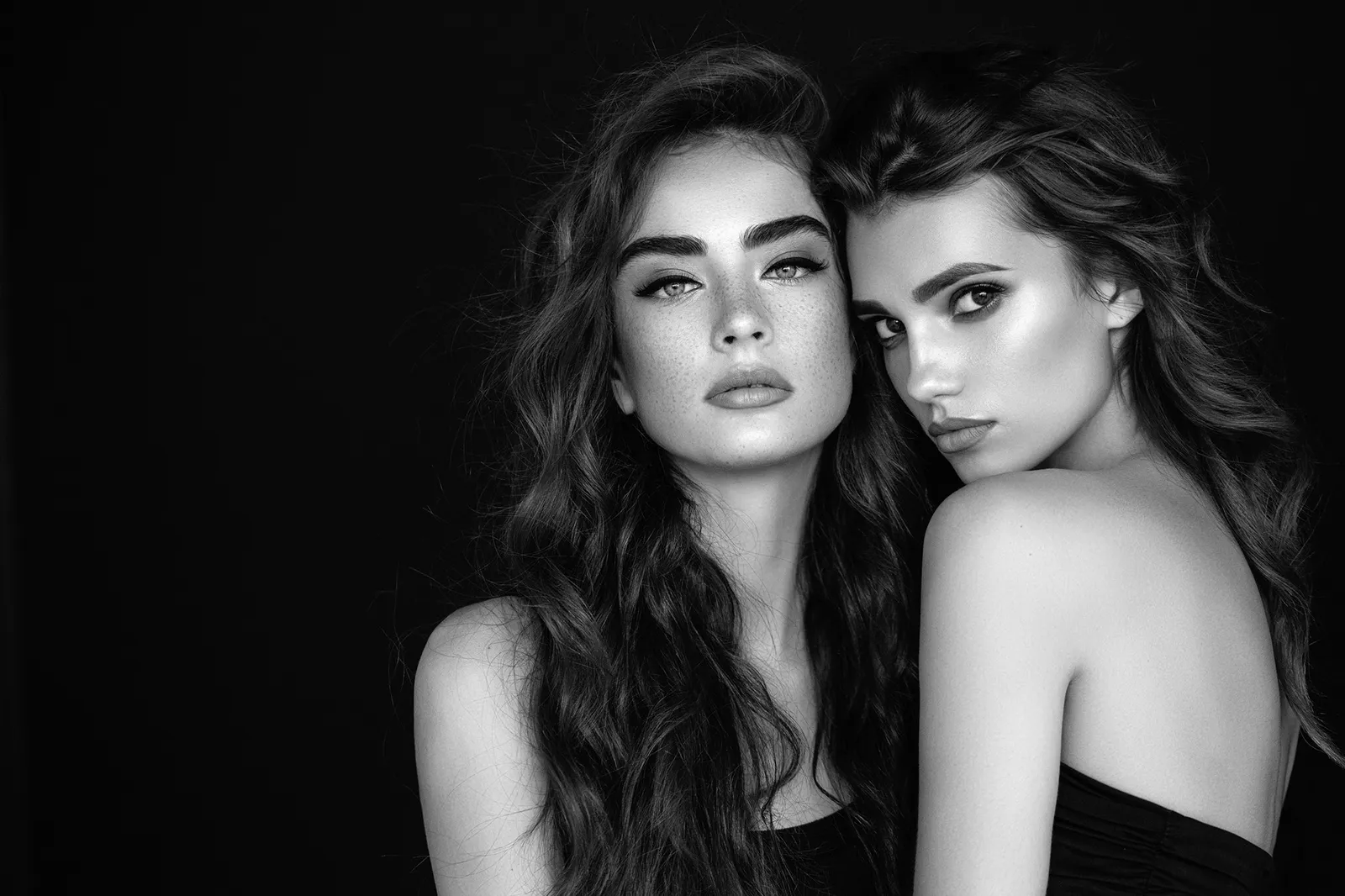 Zwart-witportret van twee vrouwen met lange golvende lokken